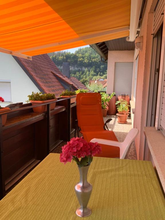 a vase with flowers on a table on a balcony at Ferienwohnung Leonhard Müller in Marktrodach