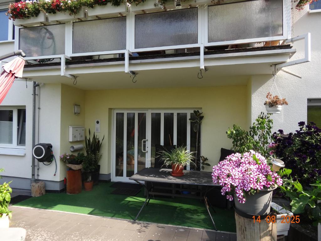 Una casa con una mesa y plantas en macetas. en Kleine Einliegerwohnung- komfort Home!, en Lahnau