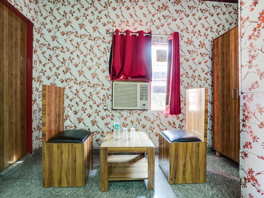 a room with a table and two stools and a window at Hotel O Astoria in Zirakpur