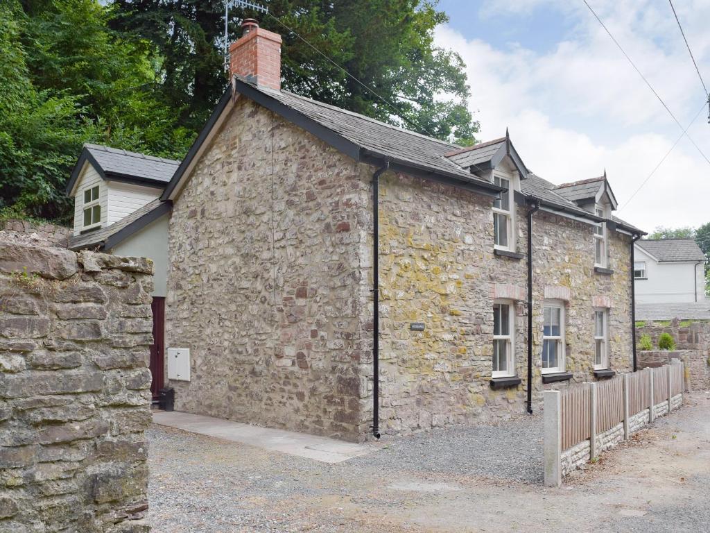 an old stone house with a brick building at Woodlands in Laugharne