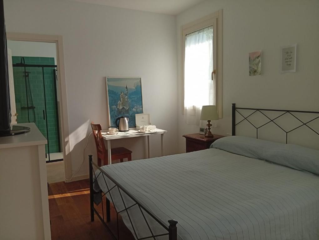 a bedroom with a bed and a desk and a window at La Casa di Cristina in Martellago