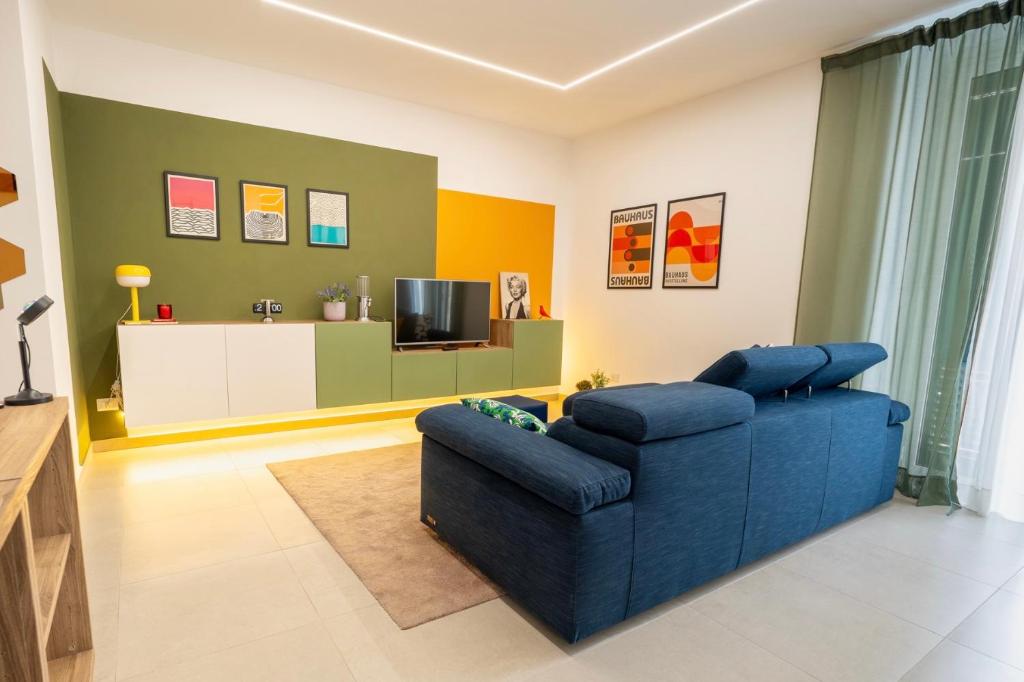 a living room with a blue couch and a tv at Colorama Home in Catania