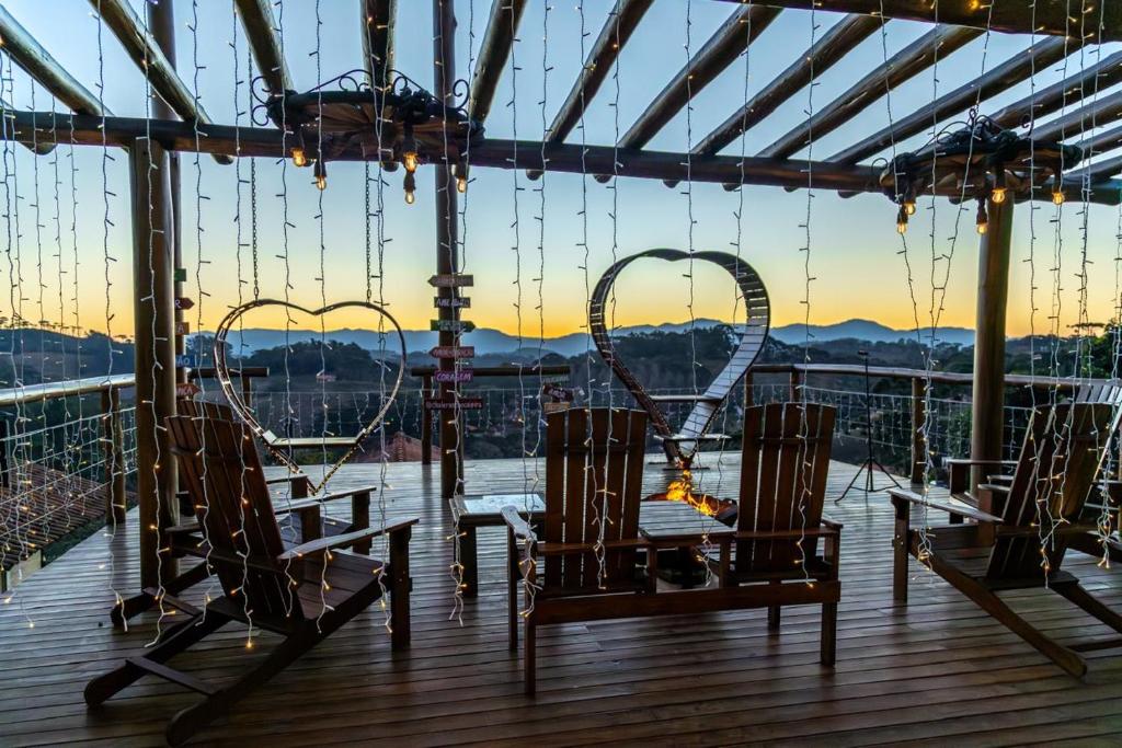 a table and chairs on a deck with a view at Pousada Chales Rancho Caipira in Santo Antônio do Pinhal
