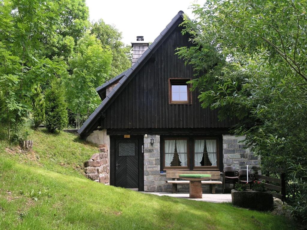a small house with a bench in front of it at Historisches Ferienhaus im Schwarzwald in Sankt Georgen im Schwarzwald