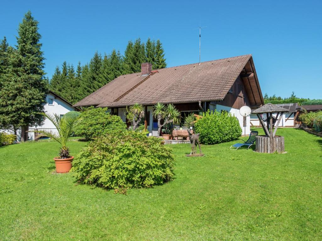 a house with a dog standing in the yard at Ferienwohnung in Gütenbach in Furtwangen
