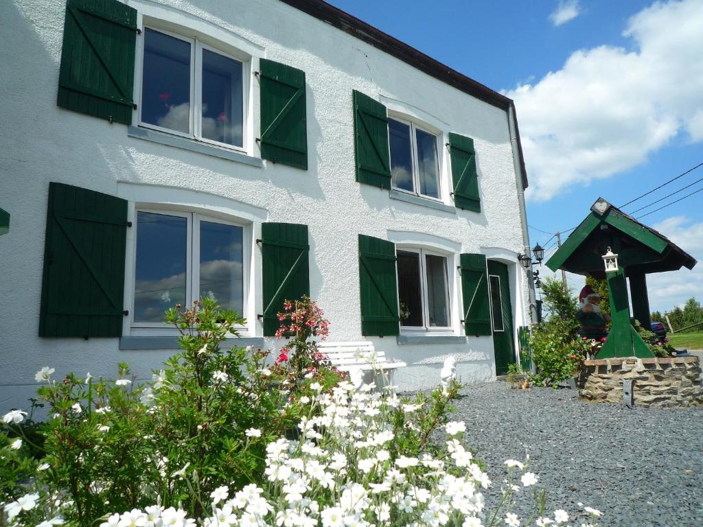 a white house with green shuttered windows and flowers at Beautiful and Authentic Cottage in Houffalize