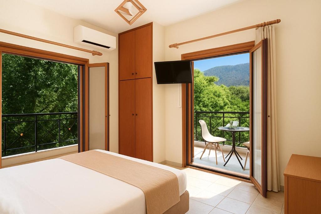 a bedroom with a bed and a balcony with a table at Artemida Pansion Georgioupolis in Kournás