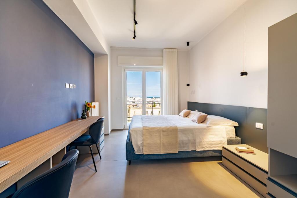 a bedroom with a bed and a desk and a window at MyHouse B&B - Trani dall'alto in Trani