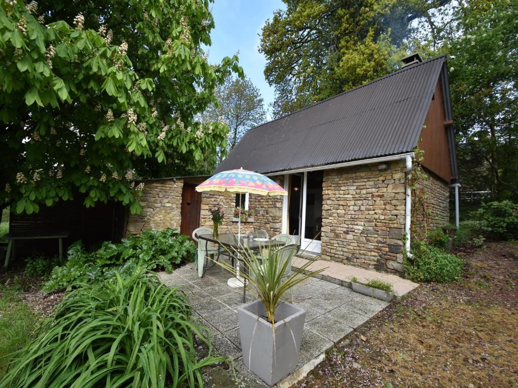 a table with an umbrella in front of a building at Normandy Bakery Retreat in Fourneaux