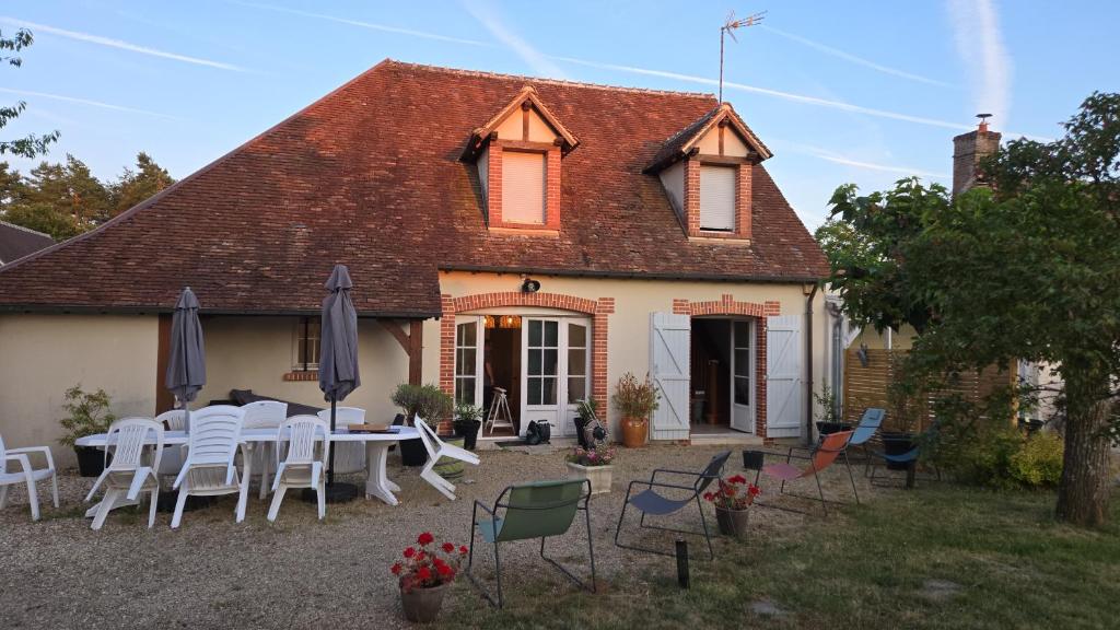 a house with a table and chairs in front of it at Chez Monique - Mur de Sologne - 8 personnes in Mur-de-Sologne