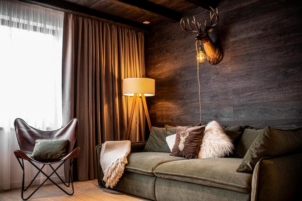 a living room with a couch and a chair at Avalanche Chalet in Poiana Brasov