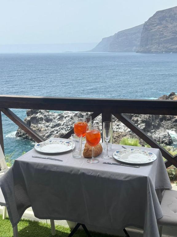 a table with plates and glasses on top of the ocean at SUL MARE in Puerto de Santiago