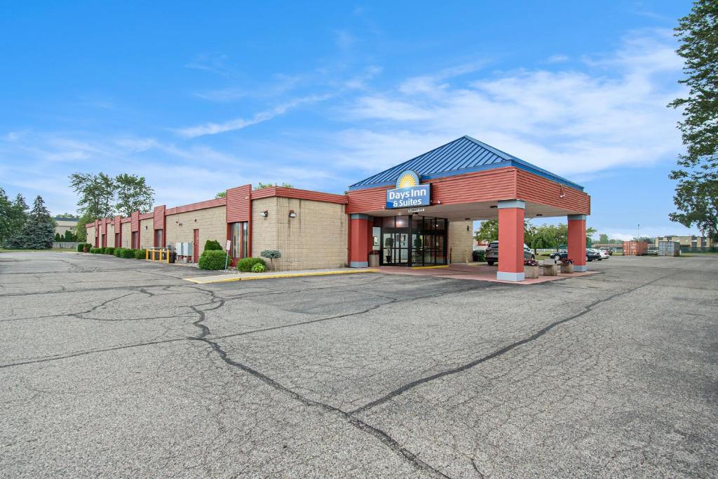 a building with a parking lot in front of it at Days Inn & Suites by Wyndham Mt Pleasant in Mount Pleasant