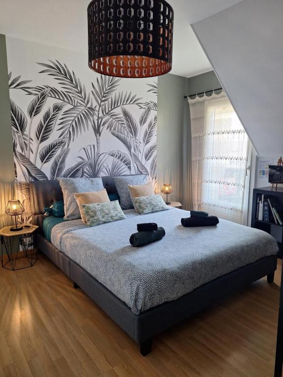 a bedroom with a large bed with two black hats on it at Chambre climatisée au cœur de brive avec téléviseur connecté wifi Netflix in Brive-la-Gaillarde