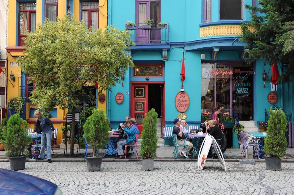 a group of people sitting at tables in front of a blue building at Kybele Hotel in Istanbul