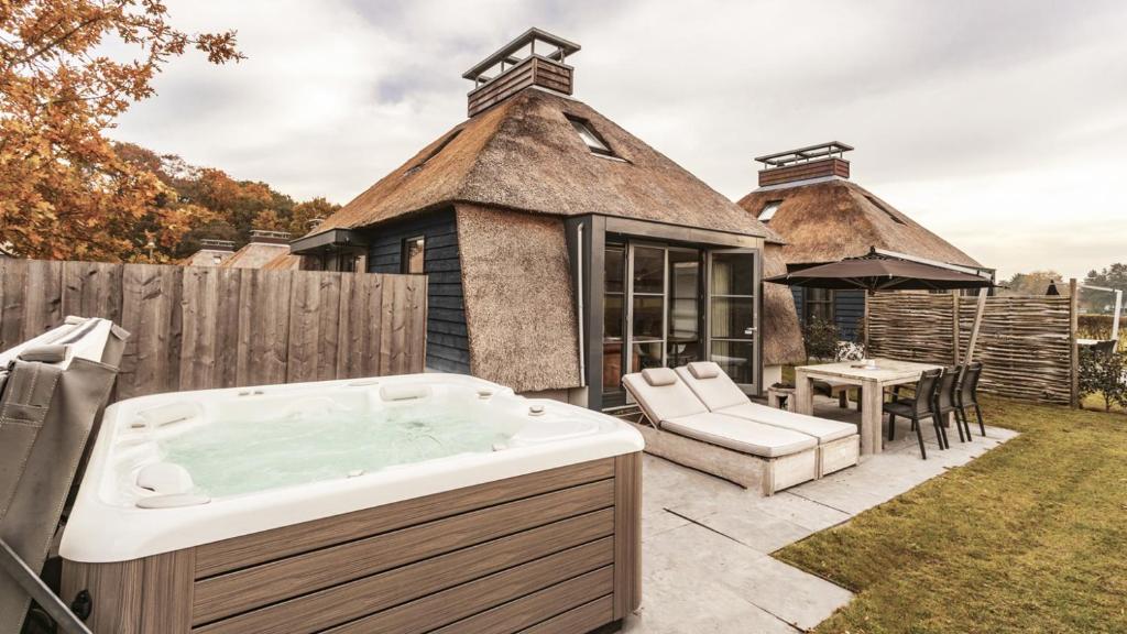 a hot tub in the yard of a house at Dutchen Park Weideduyn in Schoorl