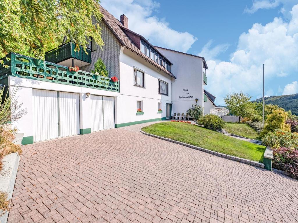 a brick driveway in front of a white house at Geräumiges Apartment am Waldrand im Sauerland in Medebach