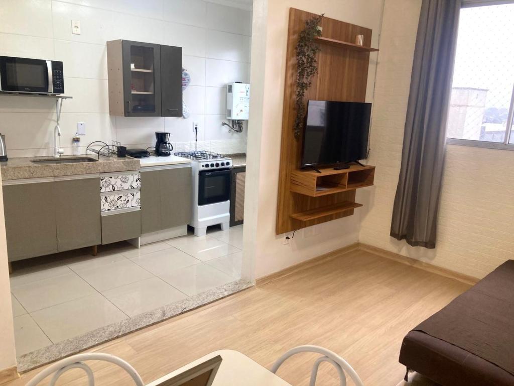 a small kitchen with a stove and a tv at Apartamento em Gravataí in Gravataí