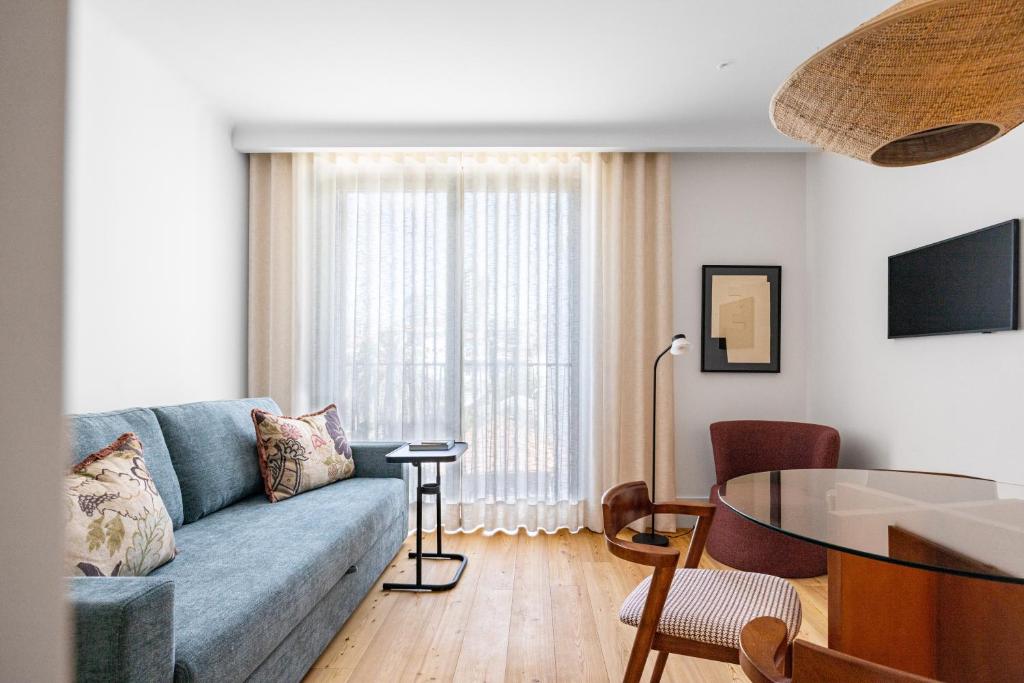 a living room with a blue couch and a table at Chic 1-BR Flat in Award-Winning Building in Bicas