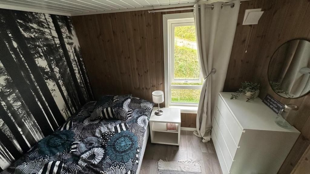 a small bedroom with a bed and a window at Villa Sjøsiden in Lii