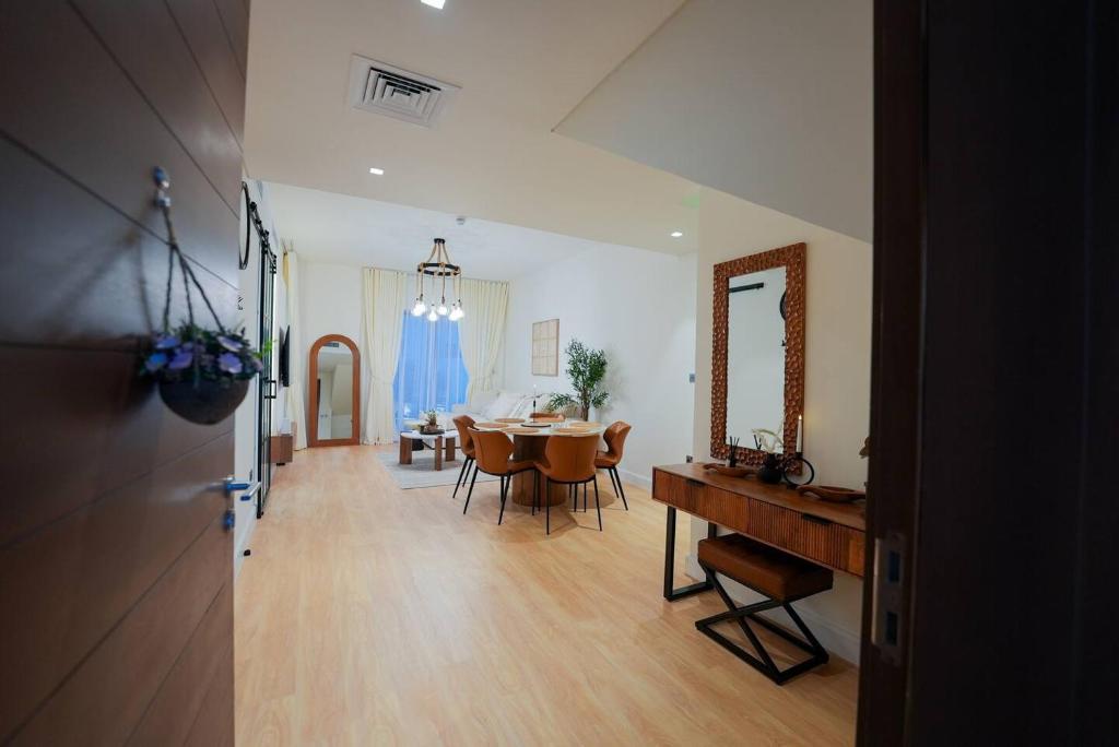 a dining room with a table and a mirror at Yas Parks Signature Villa by GBX in Abu Dhabi