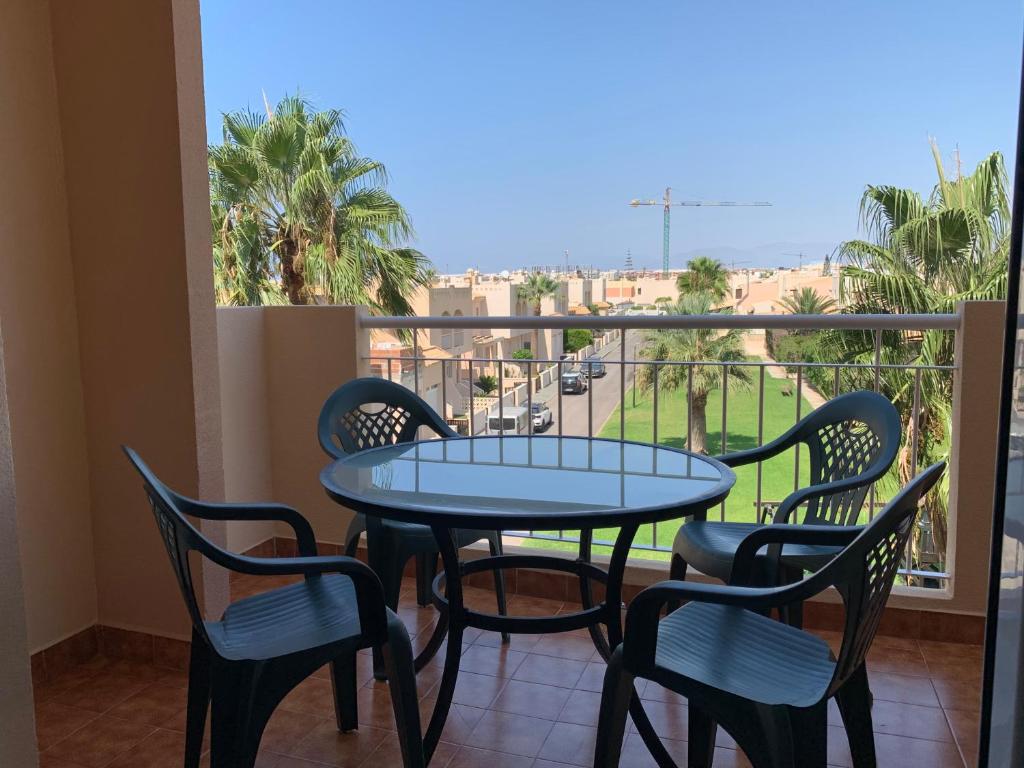 Una mesa y sillas en un balcón con vista. en Apartamentos San Miguel 2, en Almerimar