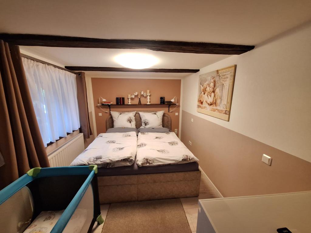 a small bedroom with a bed and a window at FeWo Am alten Holzplatz in Drübeck