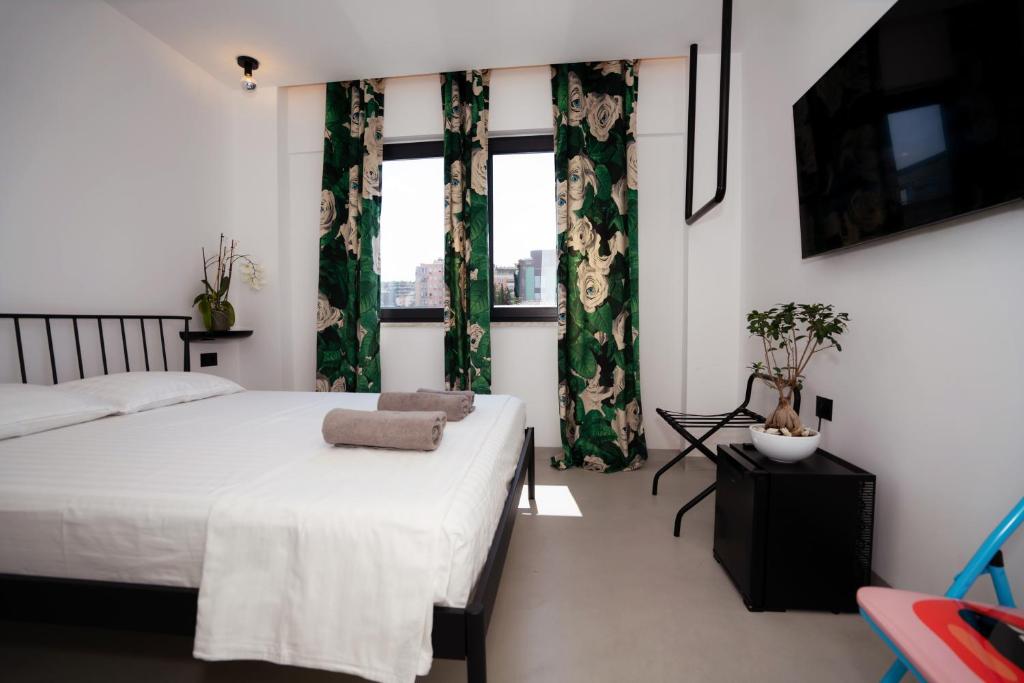 a bedroom with a bed and a window with curtains at Splendida Vita in Tirane