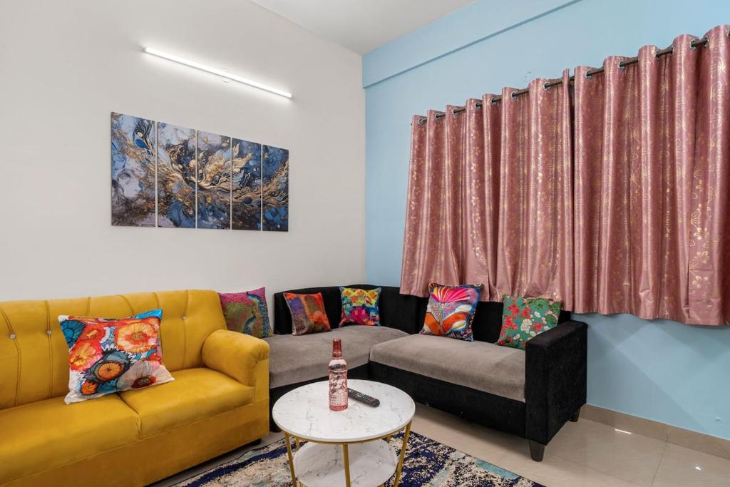 a living room with a yellow couch and a table at 303 Woods 2BHK Lift, Koramangala 100feet road in Bengaluru