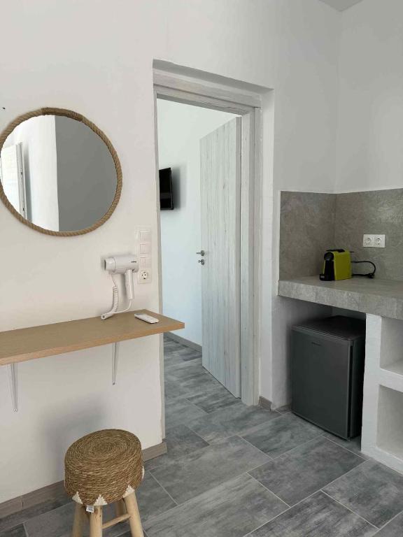 a bathroom with a vanity and a mirror and a stool at Cycladic View III in Ios Chora