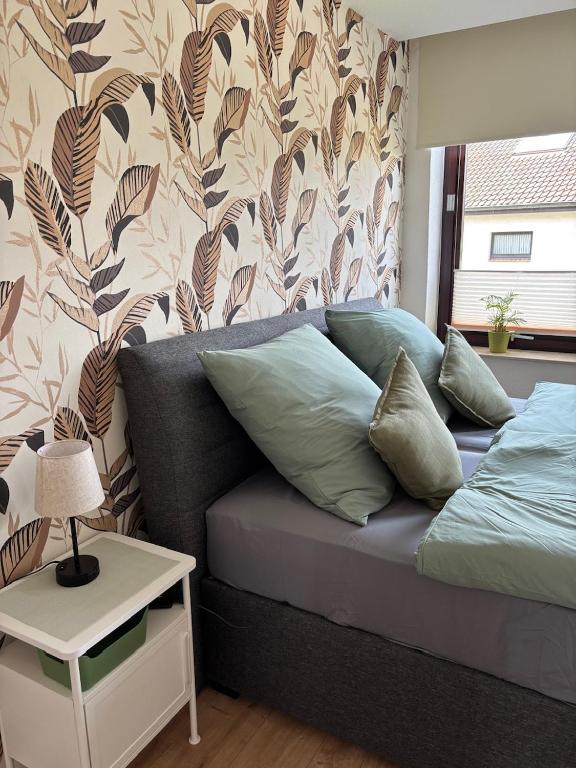 a bedroom with a bed and a wall with a flower pattern at Ferienwohnung, Apartment Schwertherz in Wulfsen