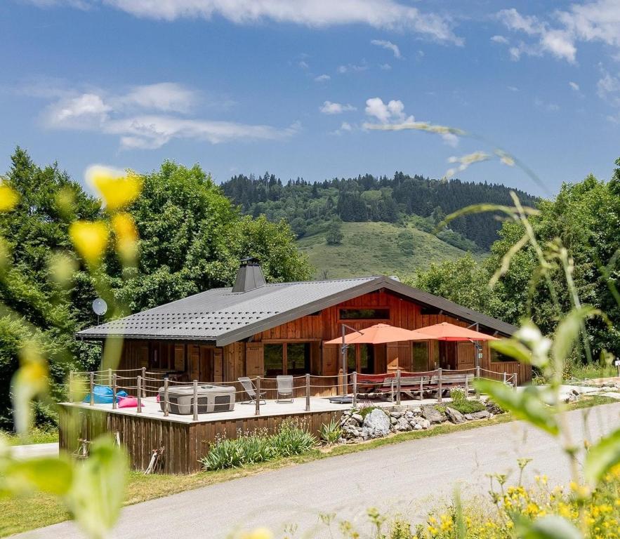 a house in the middle of a field with a mountain at La Grange de Véro in Habère-Poche