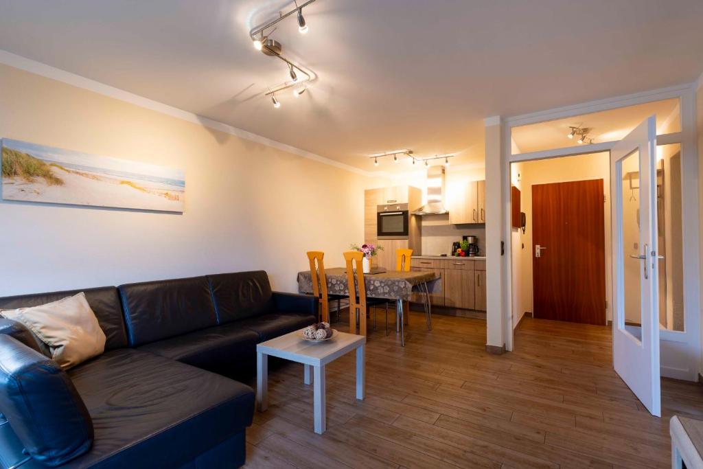 a living room with a couch and a table at _DKK1d_ Ferienwohnung Seemoewe in Niendorf