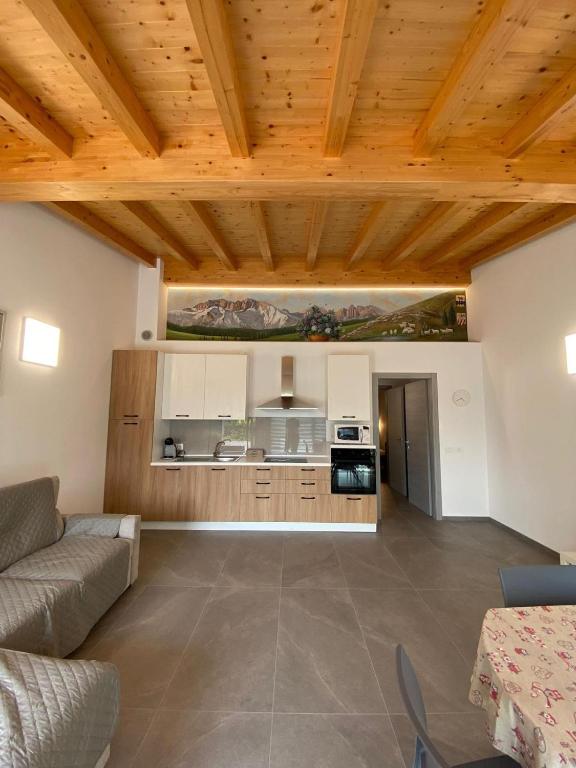 a living room with a couch and a kitchen at Chalet Marghe 1 in Rovetta