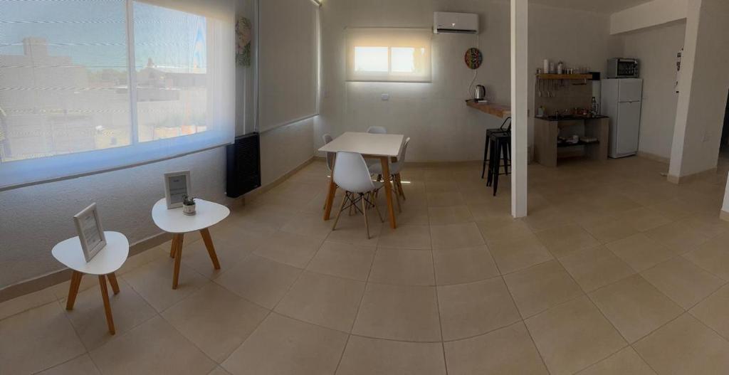 a room with two tables and chairs and a kitchen at alquiler diario el palmar in Cinco Saltos