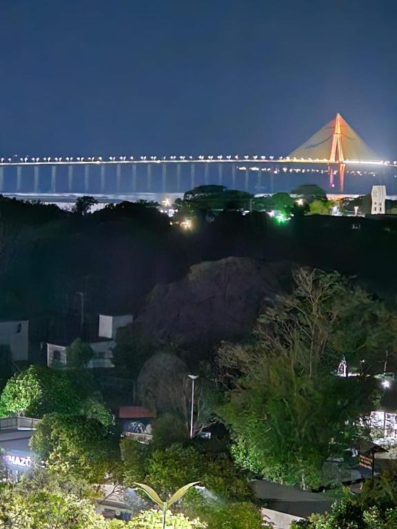 a bridge over a city at night with a bridge at Apartamento confortável in Manaus