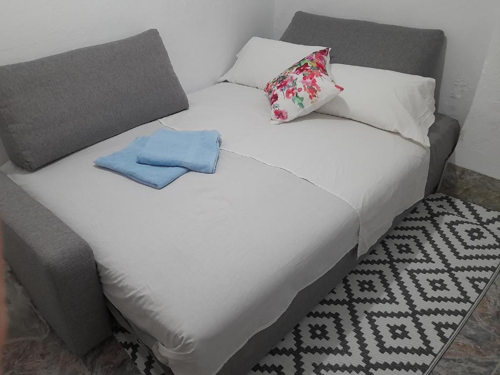 a white bed with two pillows and two towels on it at A Beautiful Townhouse in Rute