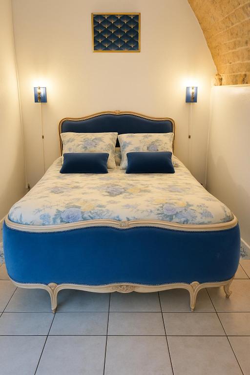 a blue bed with two pillows in a room at Château des Princes "Prince Cupidon" in Sedan