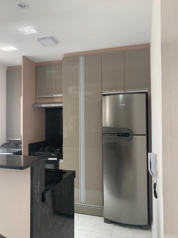 a kitchen with a stainless steel refrigerator and cabinets at AP 303 Bloco 15 in São Leopoldo
