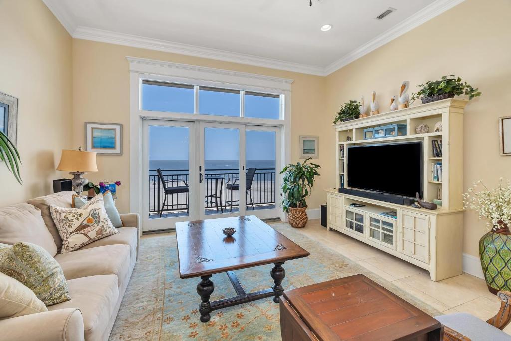 a living room with a television and a table at Sea Point #307 in Saint Simons Island