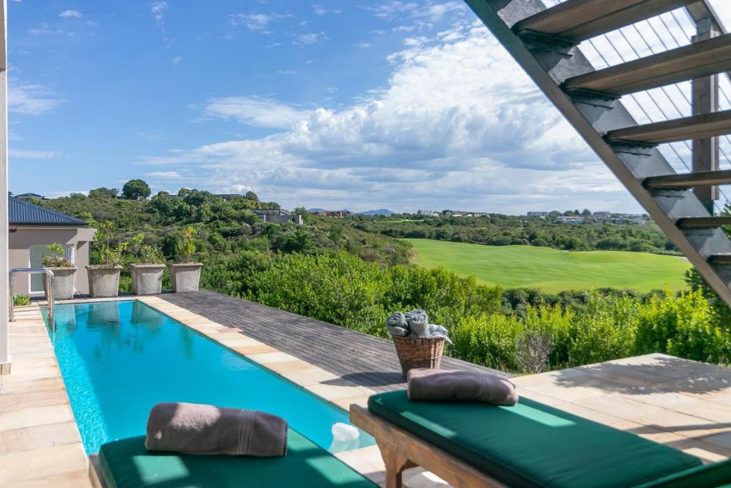 LinksView at Pezula في كنيسنا: حمام سباحة مع إطلالة على ملعب الجولف من المنزل