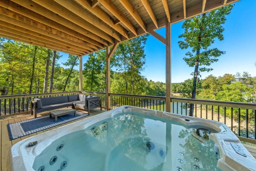 een hot tub op het terras van een huis bij Anchors Retreat - Lakefront Getaway for 14 Guests in Sevierville