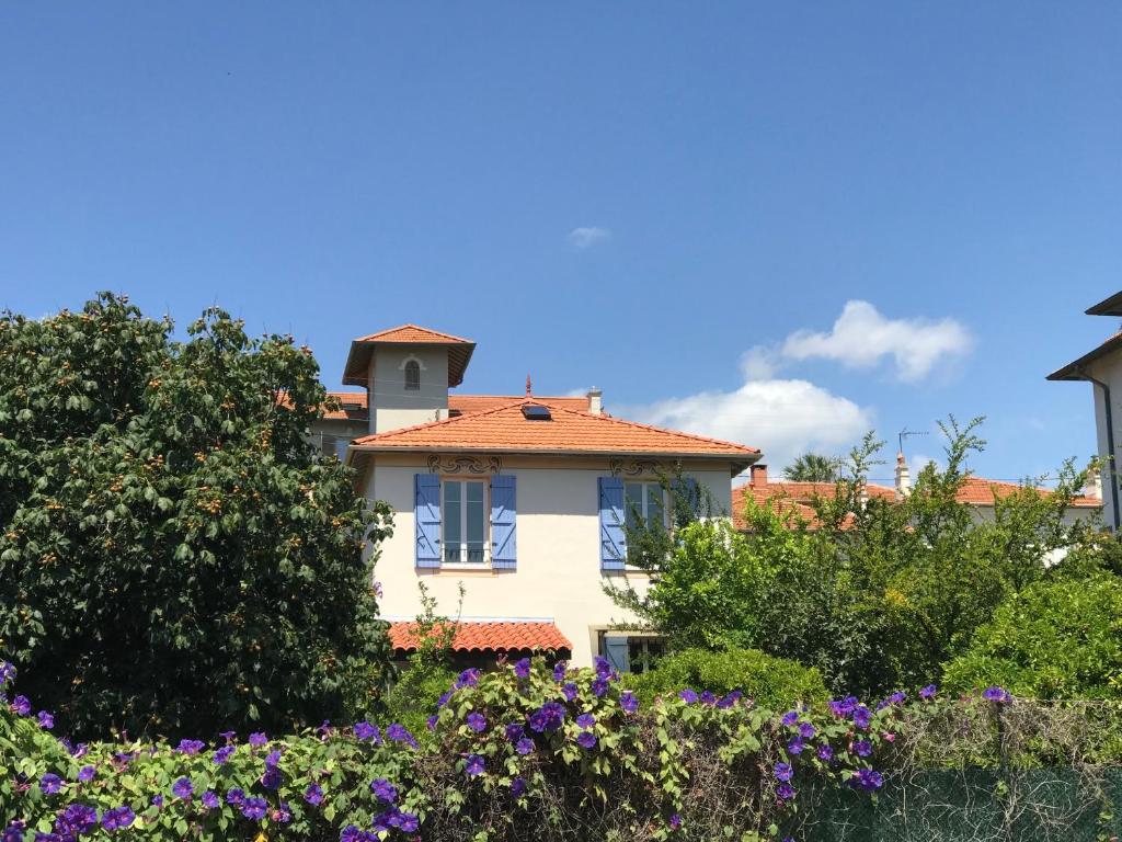 una casa con techo rojo y algunas flores en Villa cannoise en bord de mer, en Cannes