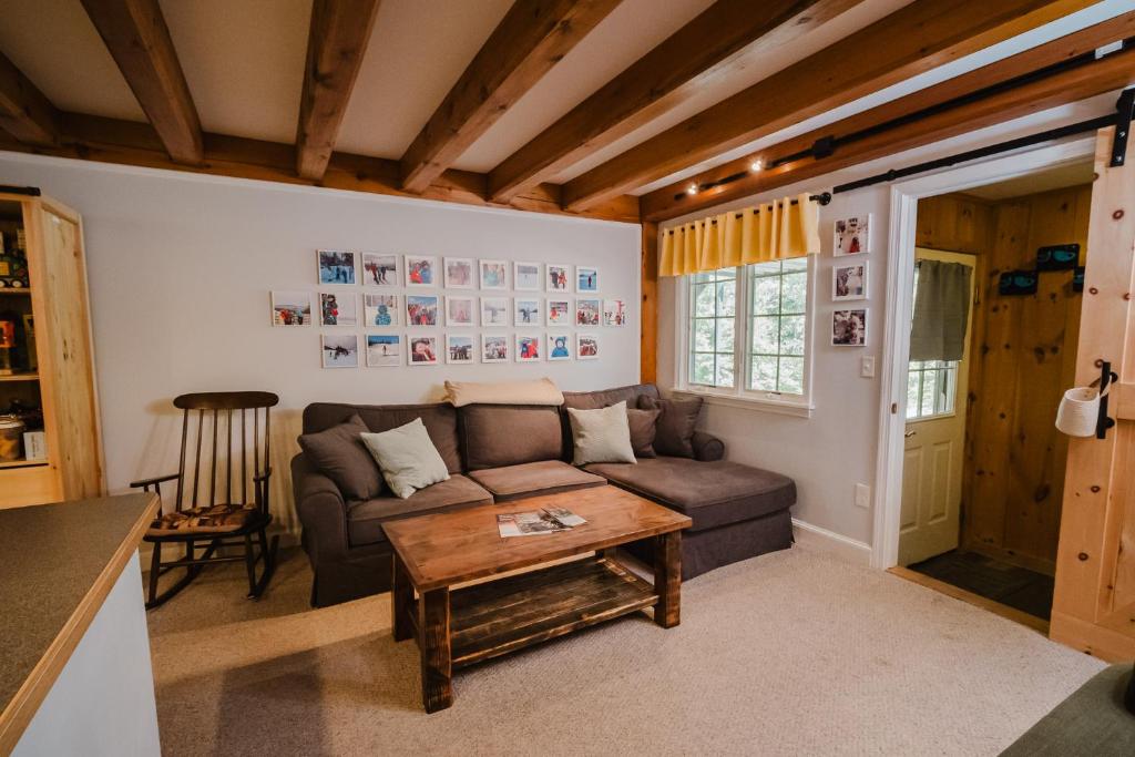 a living room with a couch and a table at Cozy Condo, Minutes from Sunday River in Bethel
