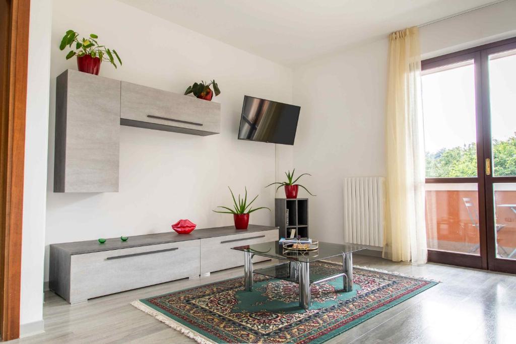 un salon avec une table et une télévision dans l'établissement OASI TRILOCALE DOPPI SERVIZI- Rho Fiera - Milano Como Lago Malpensa, à Cesate