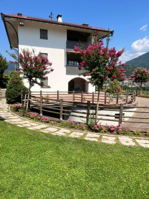 una casa con una valla y flores delante de ella en Il Gallo, en Pergine Valsugana