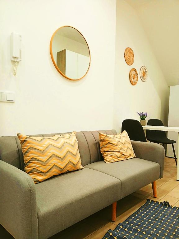 a living room with a couch and a mirror at Casa do Hilário in Viseu