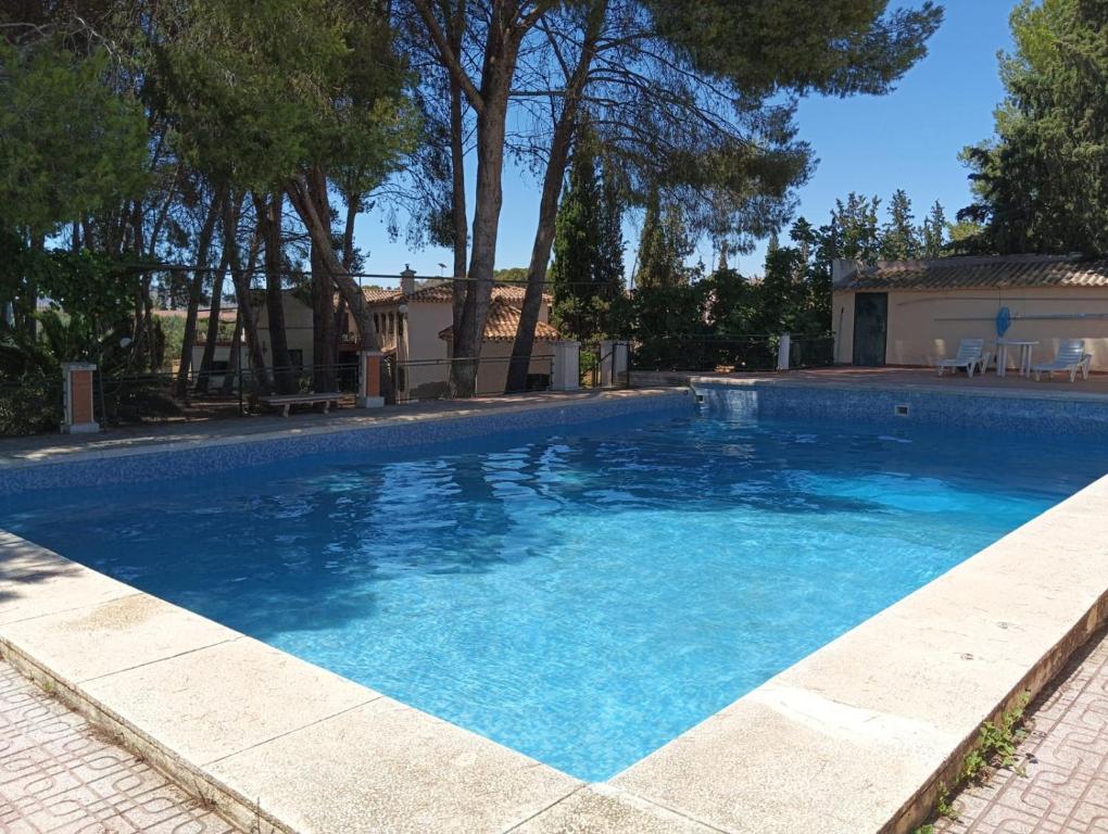 a swimming pool with blue water in a yard at Casica de Hellín in Hellín