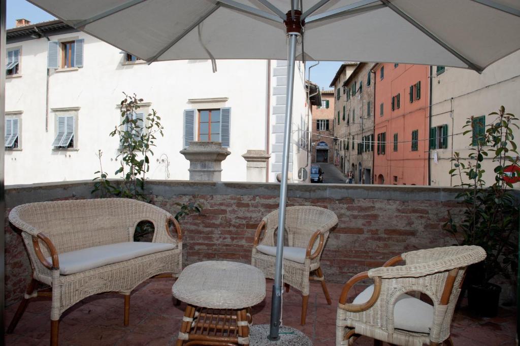 a group of chairs and an umbrella on a patio at La terrazza di Susanna in Peccioli