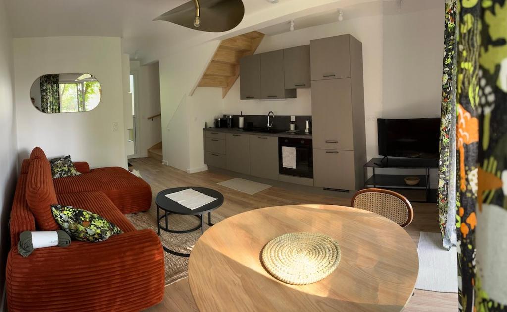 a living room with a table and a kitchen at House in a residence with swimming pool near Le Touquet Paris Plage in Saint-Josse